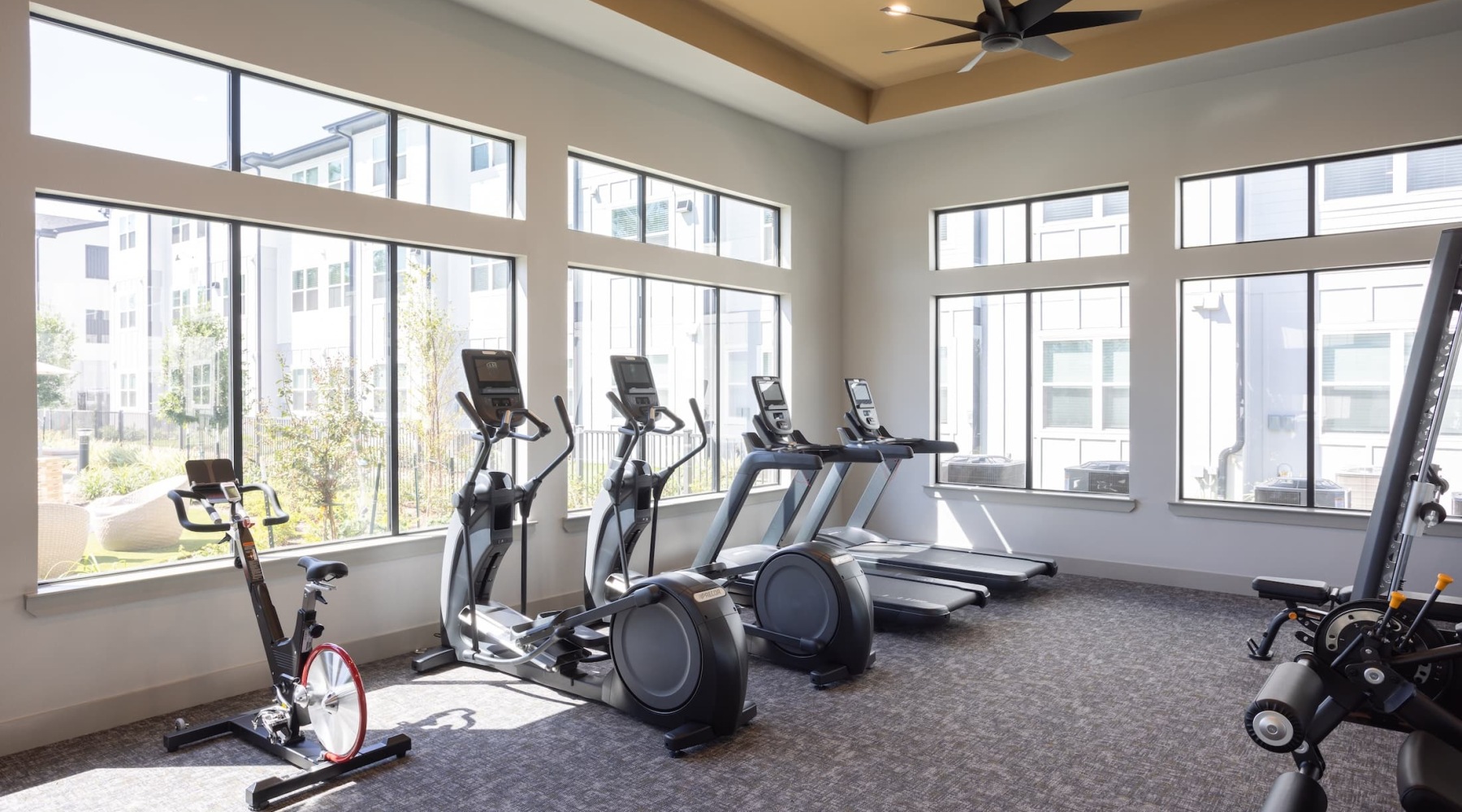 fitness area with treadmills and ceiling lighting